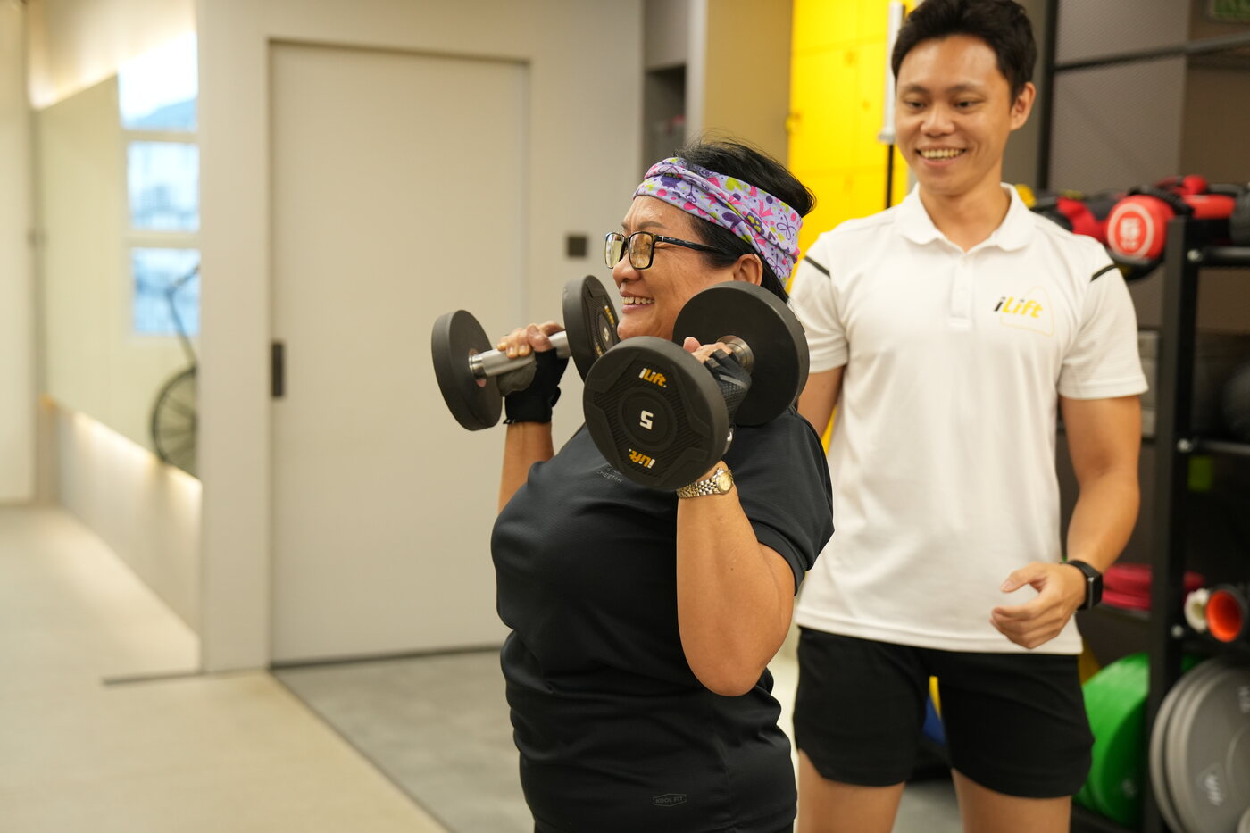 An iLift coach spotting an older client through a controlled lift