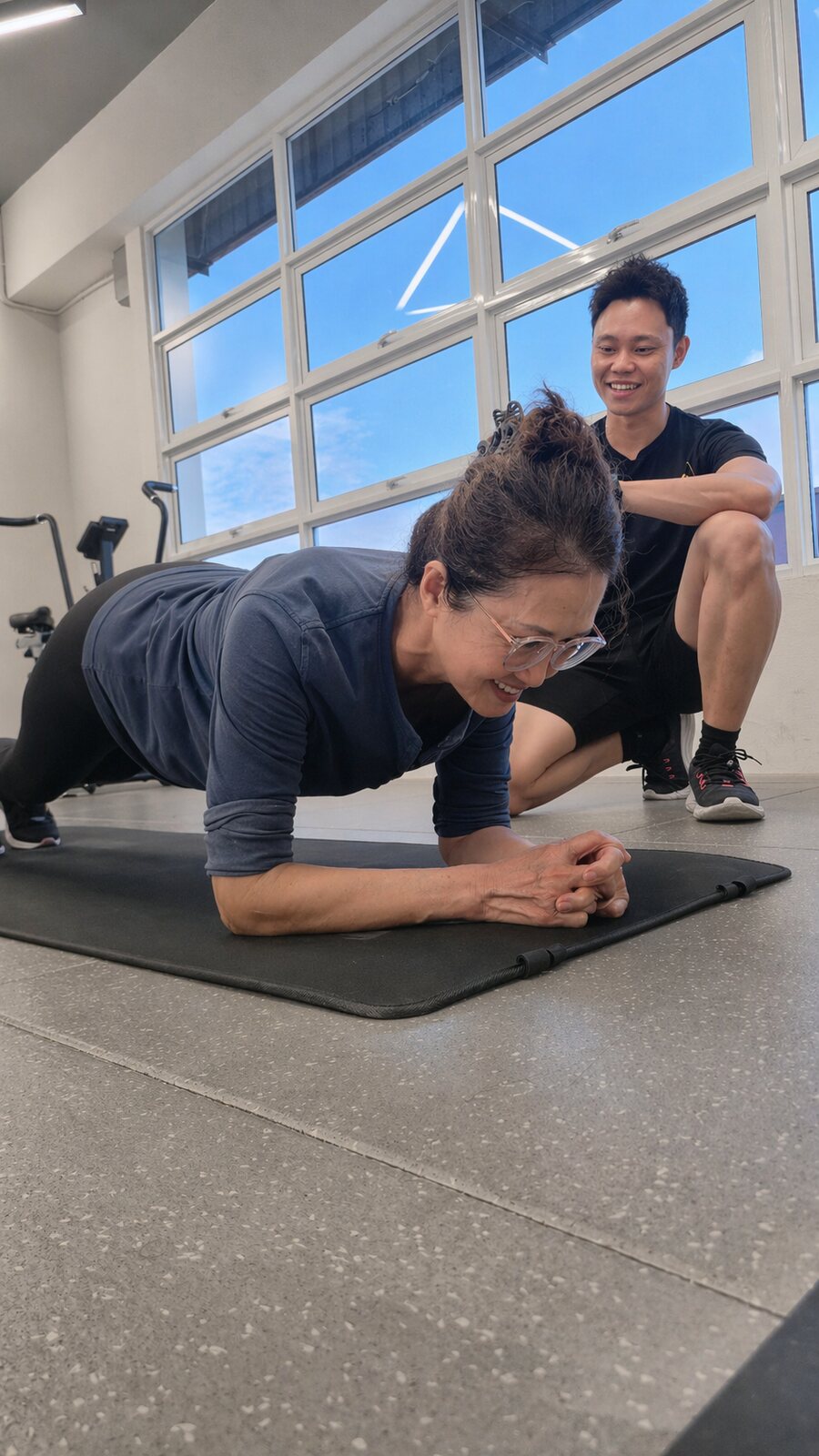 Adult client holding a plank with her coach at iLift Pines Square, MJC Kuching