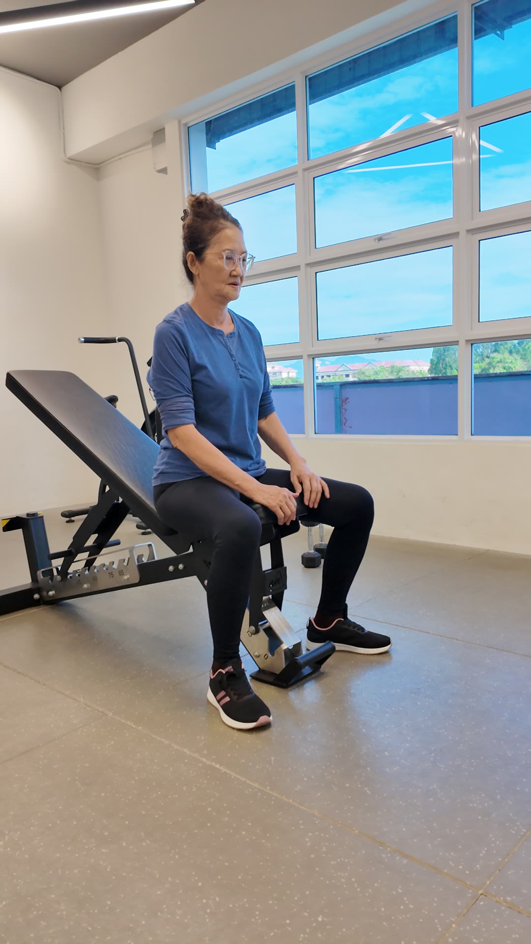 An older client sitting on a bench at iLift, the depth used for a box squat on a sore-knee day