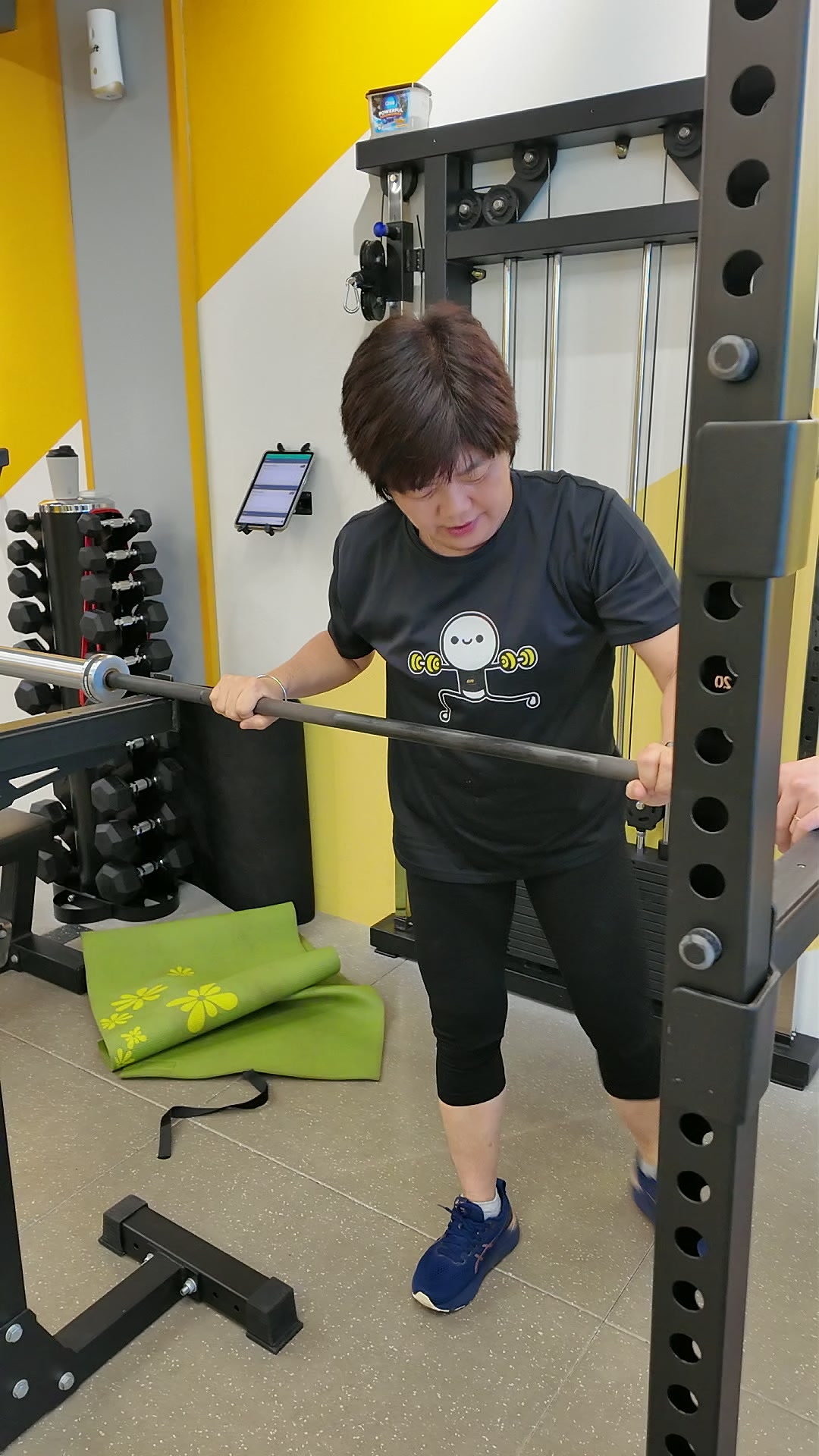 Mary doing a split squat holding a barbell in the rack at iLift Pines Square