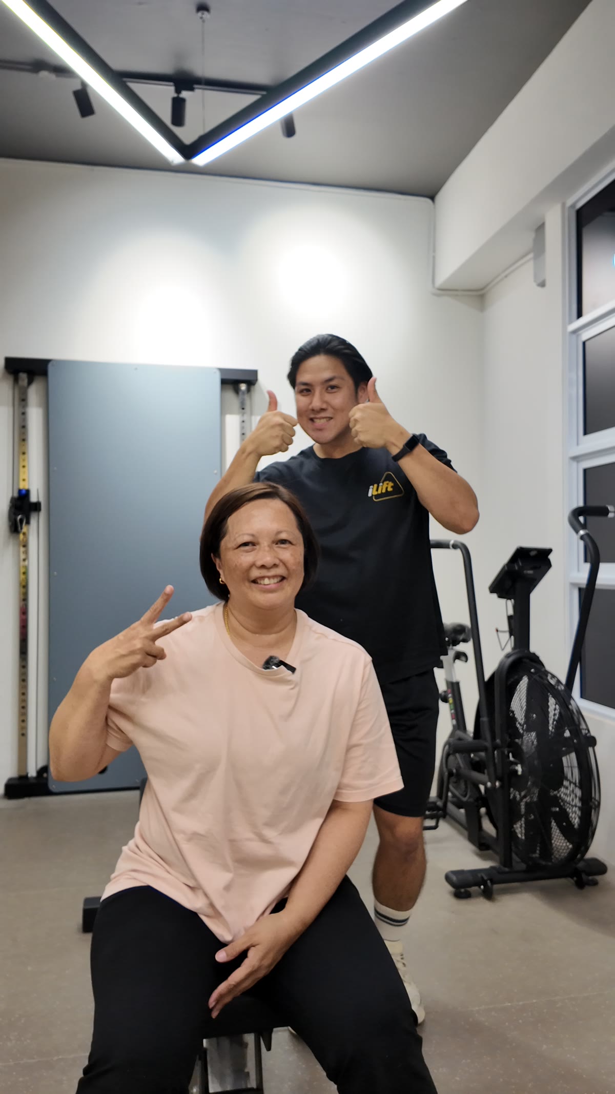 Phyllis, in her 50s, smiling with Coach Shannon at iLift Pines Square