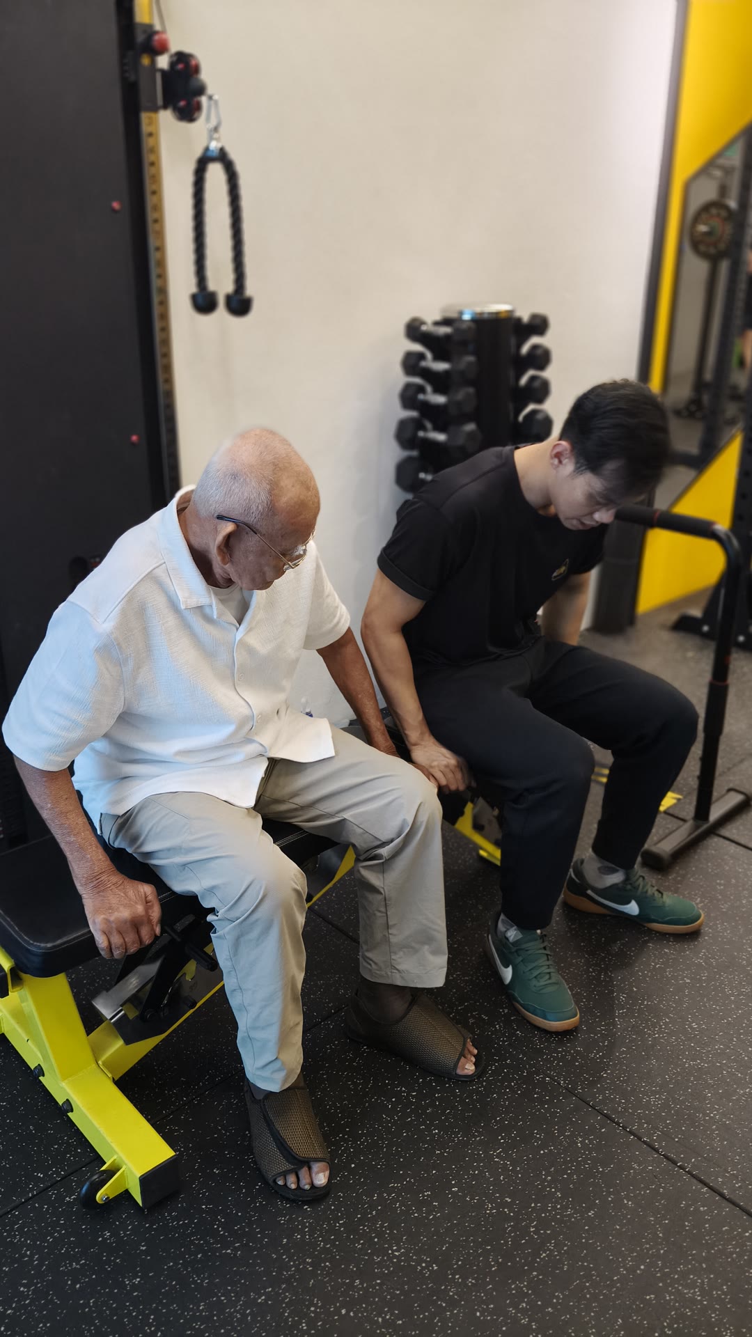 Wan standing up from a bench with Coach Matiin close by